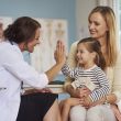 Woman doctor visiting child and mother