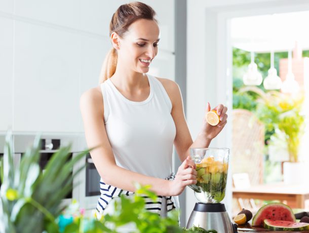 Smiling girl squeezing fruit juice